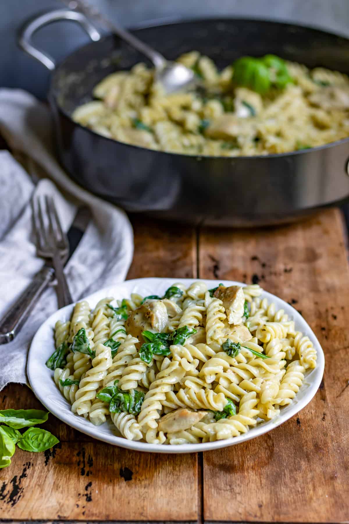 Plate of chicken pesto pasta on a table.