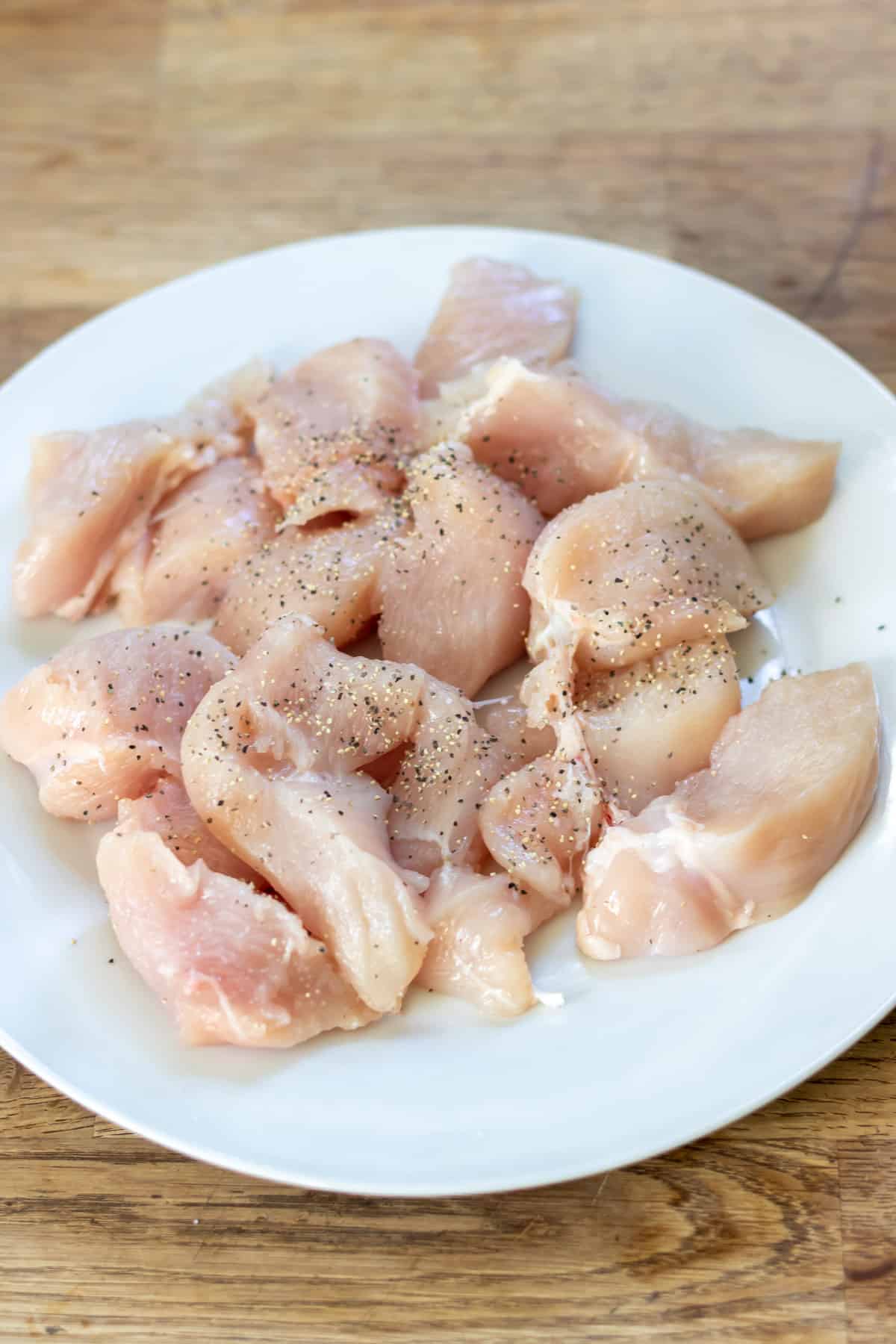 Cutting chicken breasts in to pieces.