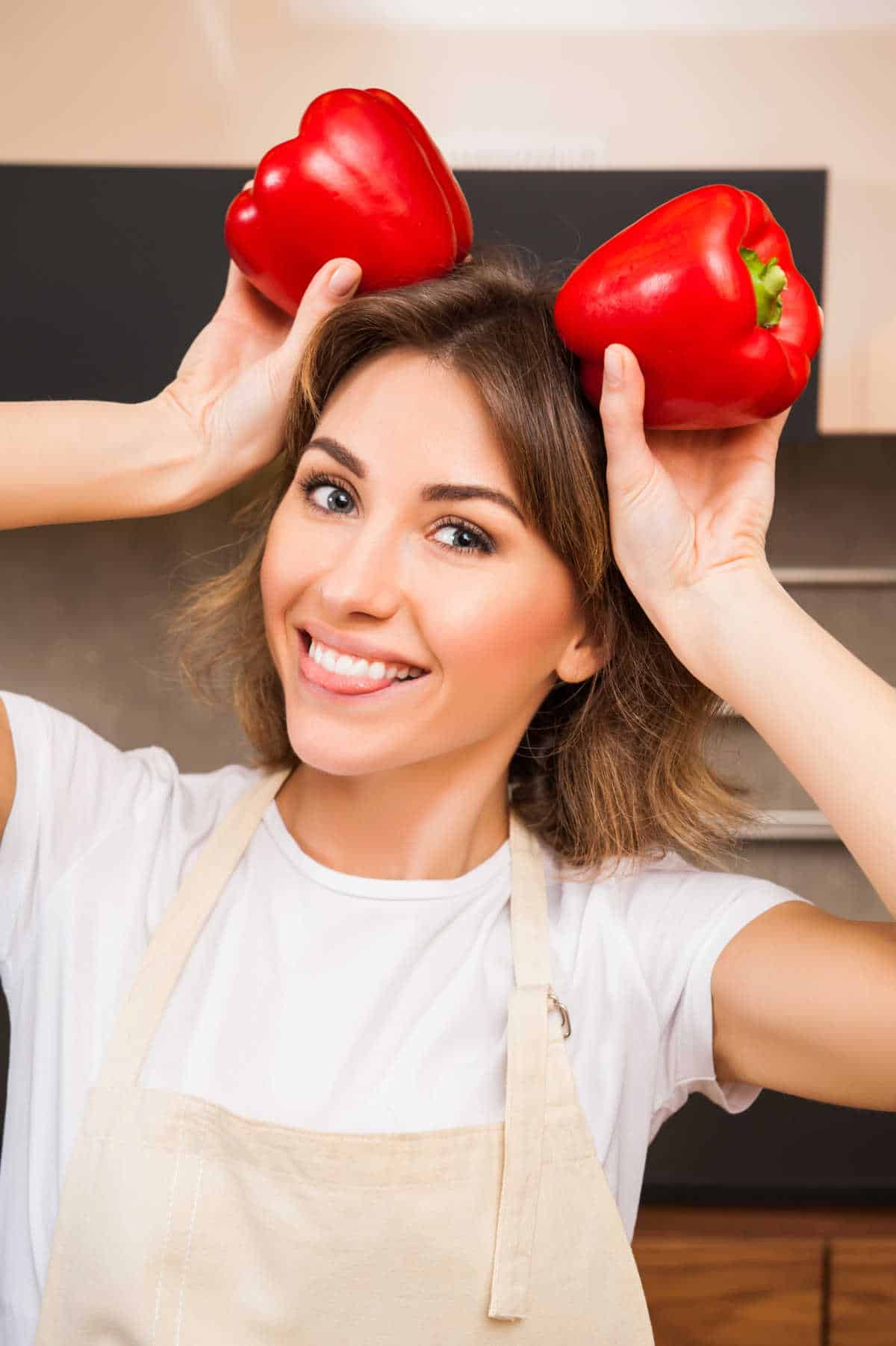 Woman holding bell peppers.