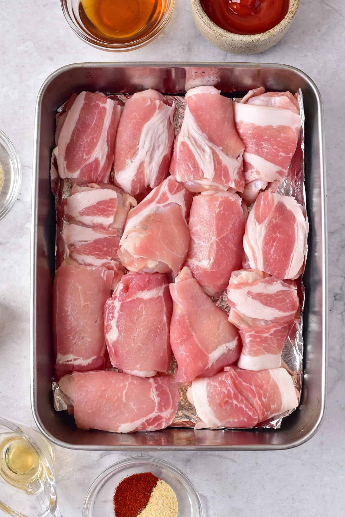 Bacon wrapped chicken wings in a baking pan.