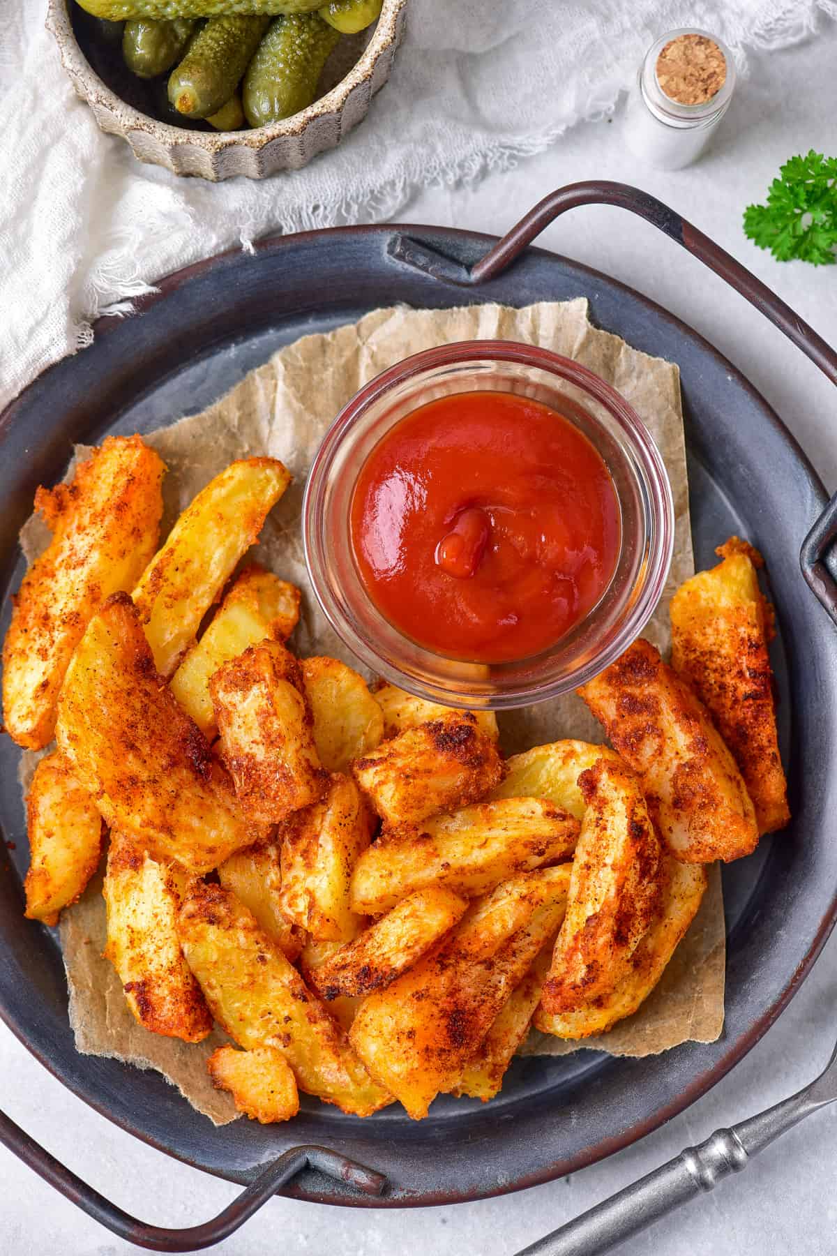 Plate of air fryer potato wedges and a dish of ketchup.