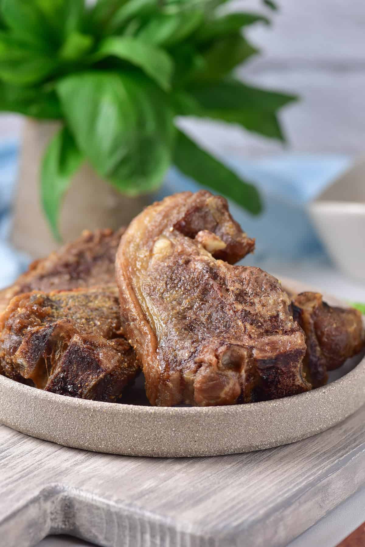Table with a plate of air fried lamb chops.