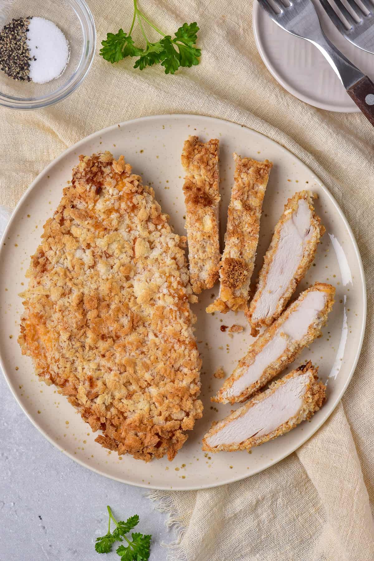 Looking down at a plate with a chicken cutlet sliced.