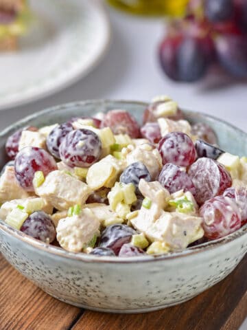 Table with a bowl of grape chicken salad.