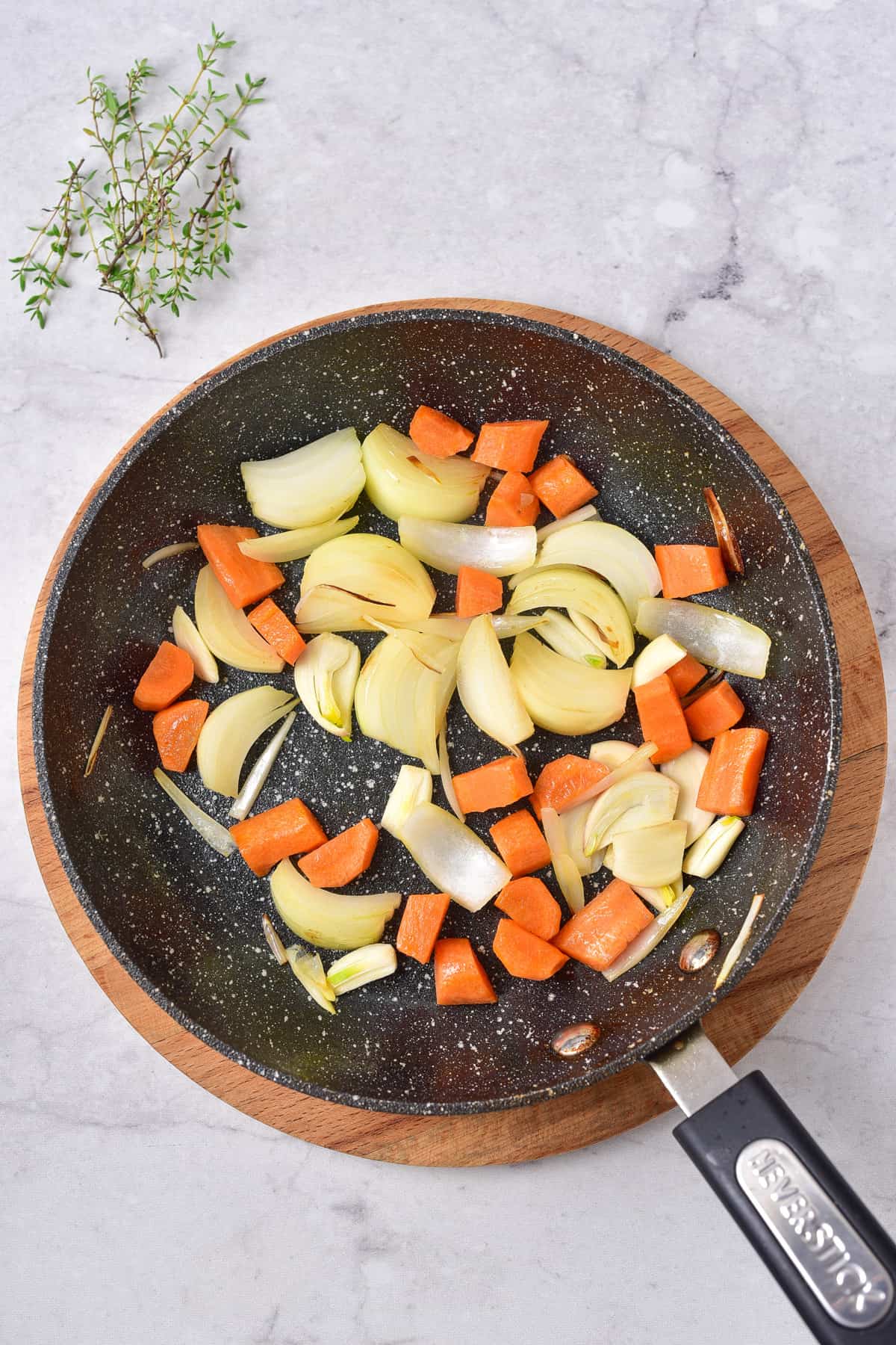 Cooking onions and carrots in a skillet.