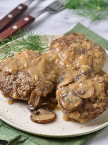 Table with a plate of salisbury steak and mushroom gravy.