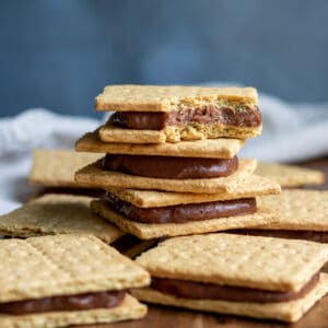 Stack of graham cracker ice cream sandwiches and the top one has a bite out.